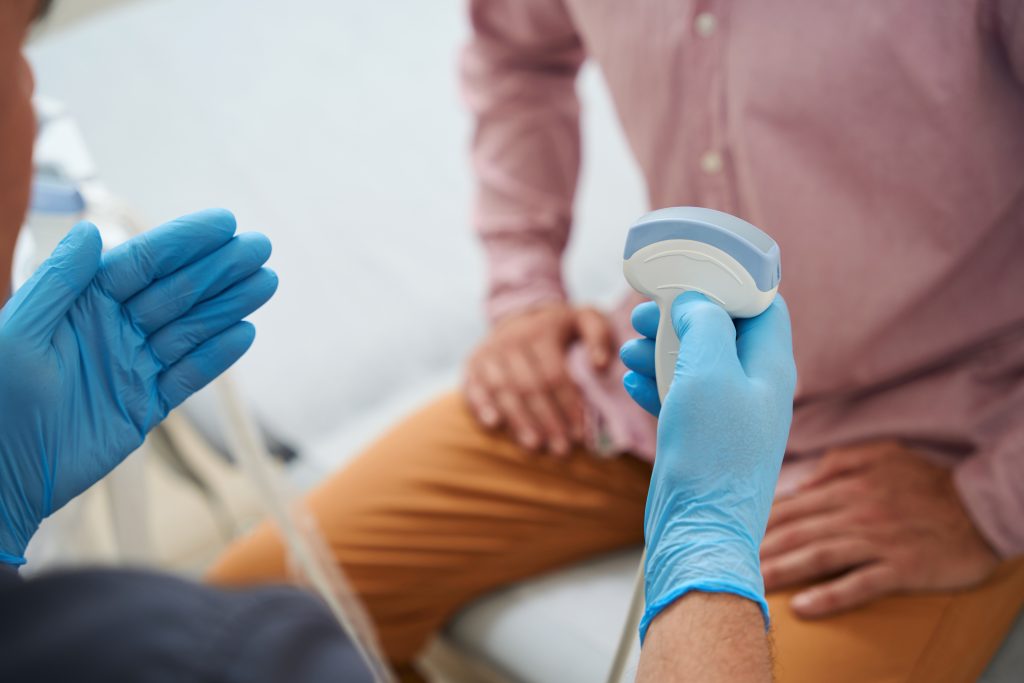 Arzt hält ein Ultraschallgerät ind er Hand