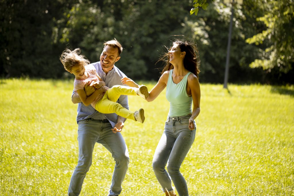 Familie mit Vater und Mutter und Tochter auf einer Wiese